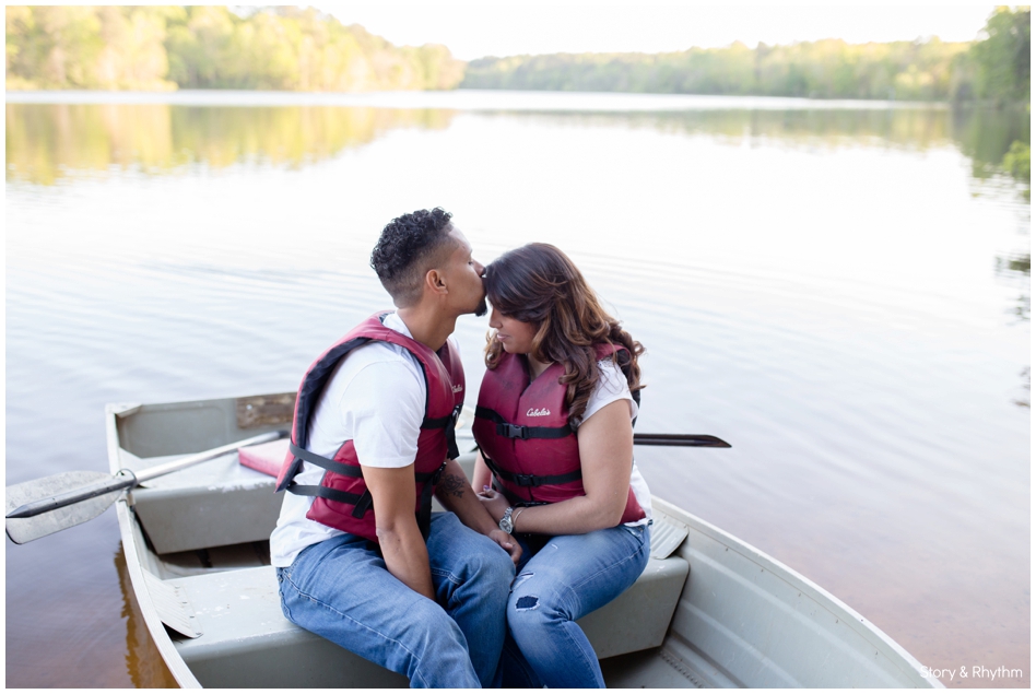 Couple kissing in row boat on North Carolina lake