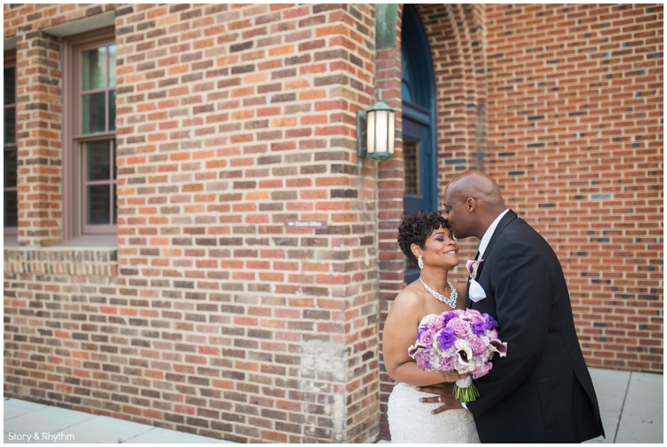 Groom kissing the bride on the forehead